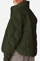 Lightweight puffer travel jacket in black with sleek design for versatile and packable warmth