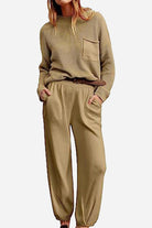 Woman wearing European Minimalism relaxed khaki sweater top and trouser set with knit pocket and loose fit.