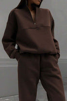 woman wearing brown cotton-blended two-piece tracksuit with high collar and deep zipper