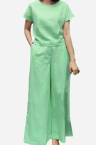 Woman wearing a green short-sleeved bell pants two-piece set with loose fit and wide-leg pants