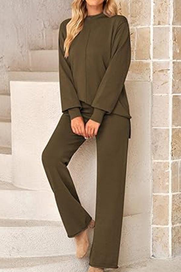 Woman wearing olive green high neck sweater and wide leg pants set standing against beige wall