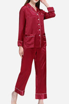 Woman wearing long sleeve silk pajamas in deep red with button-up top and matching pants