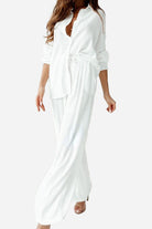Elegant white professional two-piece set with long sleeves and relaxed fit pants
