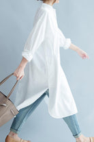 Woman wearing white pure cotton long shirt with rolled sleeves and light blue jeans carrying beige handbag