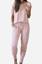 Woman wearing pink ultra-soft two-piece loungewear set with batwing sleeves and jogger pants with pockets