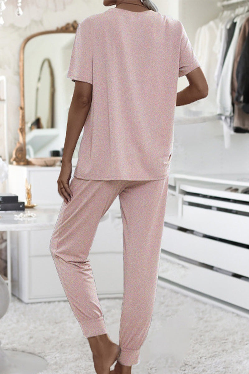 Back view of woman wearing pink ultra-soft two-piece loungewear set with batwing sleeves and jogger pants in cozy indoor setting