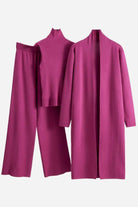 Pink three-piece collection featuring knit pants, ribbed high-neck top, and long open cardigan