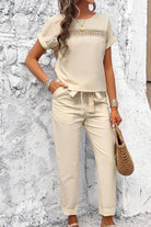 Woman wearing beige 100% cotton total comfort two-piece set with short sleeves and drawstring pants.