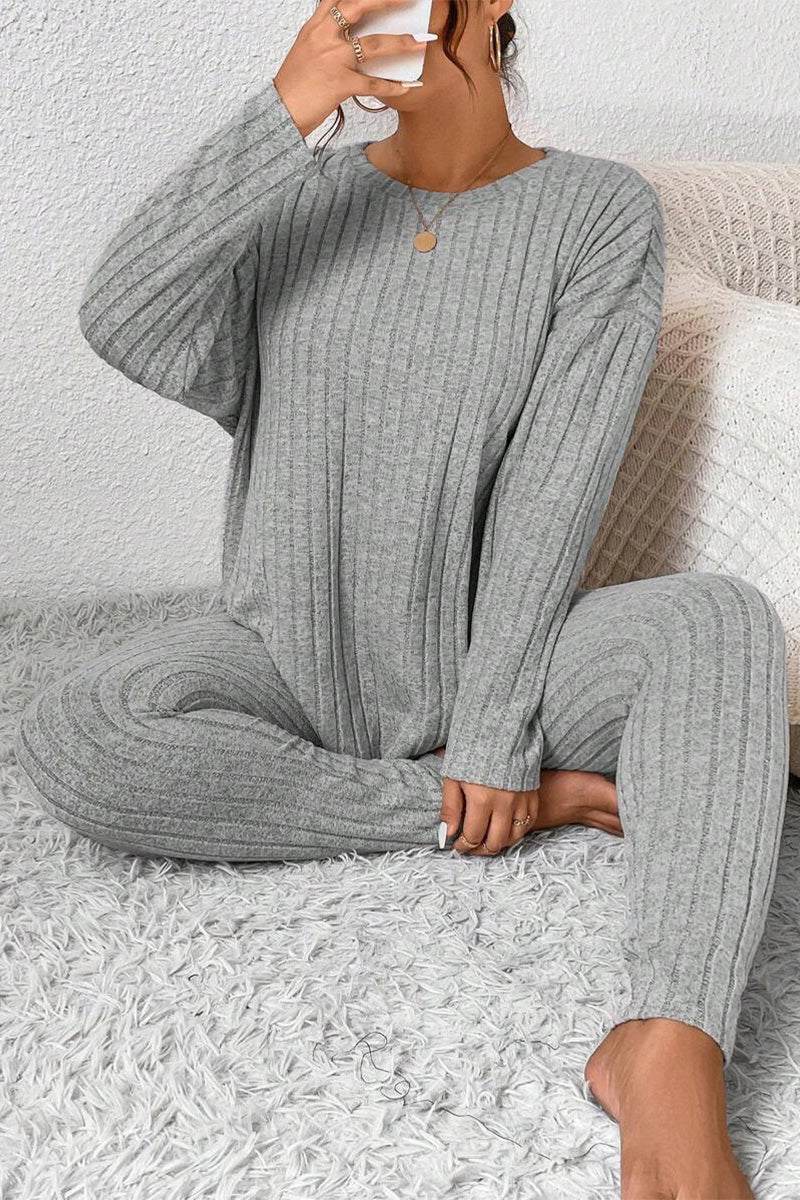 Woman wearing gray Body Confident Oversized Knit two-piece loungewear set sitting on carpet