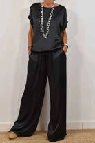 Silken Escape Satin Two-Piece Set black satin relaxed fit top and wide-leg pants with pockets and stretch waistband.