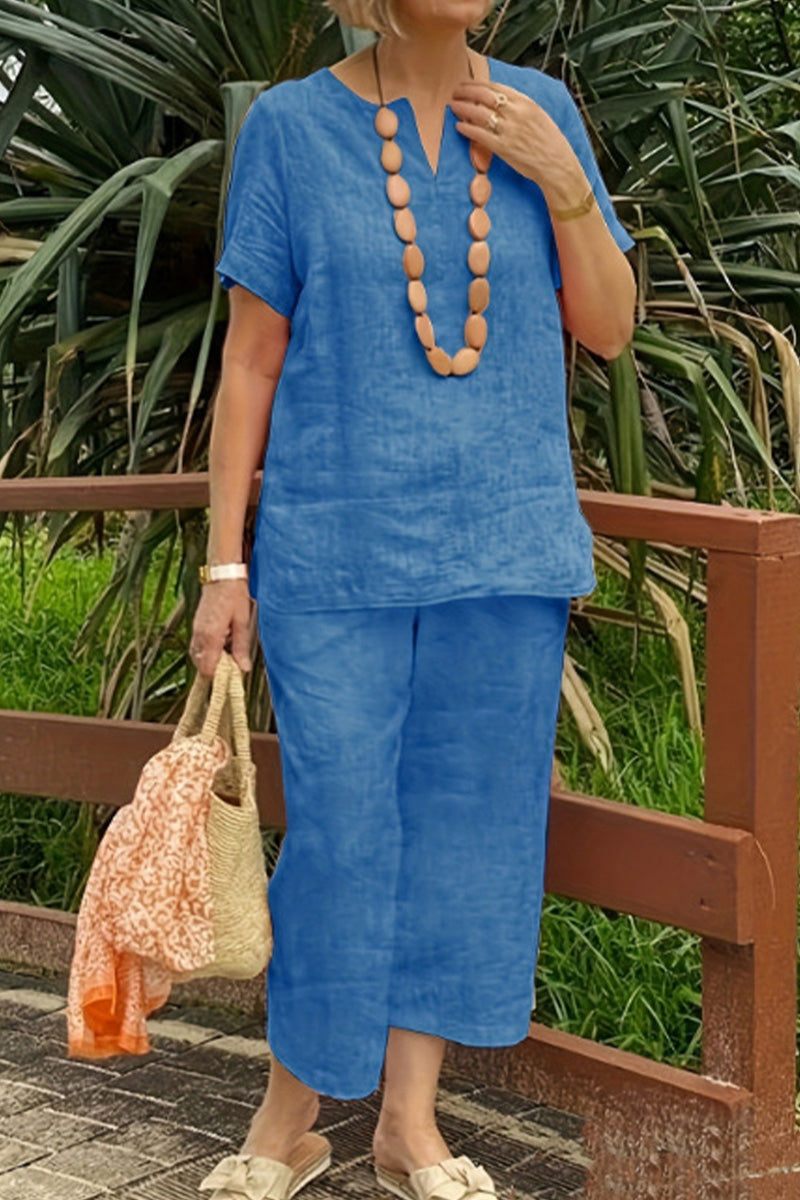 woman wearing blue breezy cotton blend two-piece set with necklace and handbag outdoors