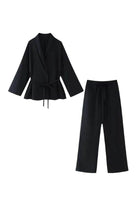 Black mix-match lounge-to-travel set with wide-leg pants and belted draped top in premium polyester