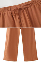 Rusty orange wide-leg pants from versatile Mix-Match Lounge-to-Travel Set with an elastic waistband and drawstring.