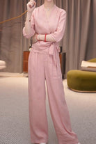 Woman wearing breathable cotton-linen pink wrap top and wide-leg pants set indoors