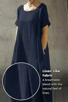 Breeze Cocoon Dress in navy with rolled sleeves, deep side pockets, and linen-like breathable fabric.
