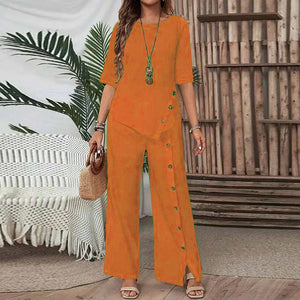 Woman wearing orange Asymmetry Flow Co-ord set with button-front top and flowing pants, styled with necklace and handbag