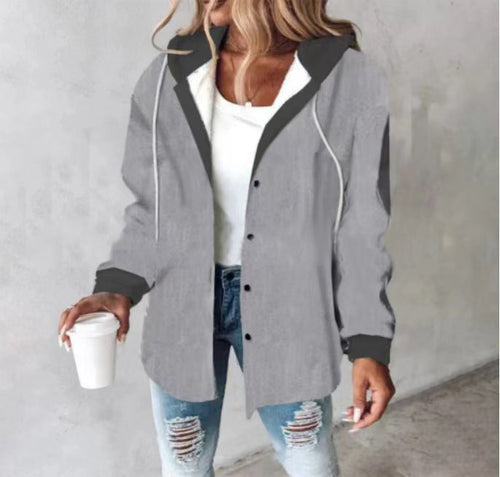 woman wearing Highland Plaid Shacket with hood and plaid pattern, layered over white top and ripped blue jeans, holding a coffee cup