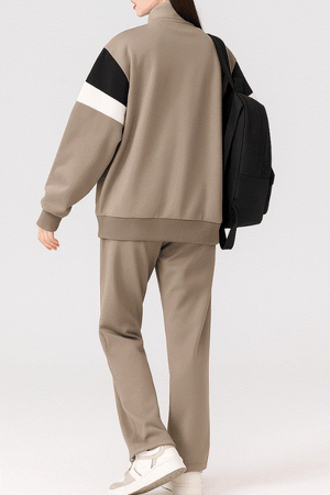 Comfort in Motion lightweight athleisure tracksuit set in taupe with black and white sleeve detail, worn with white sneakers and black backpack.