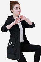 Woman wearing black Cityscape Comfort Hooded Windbreaker with mid-length fit and drawstring waist.