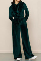 Dark green velour tracksuit with cropped hoodie and high-waist wide-leg pants on model