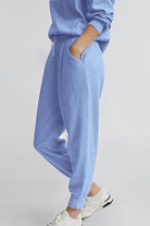Unisex half-zip pullover and sweatpants set in soft blue polyester blend for casual comfort and style