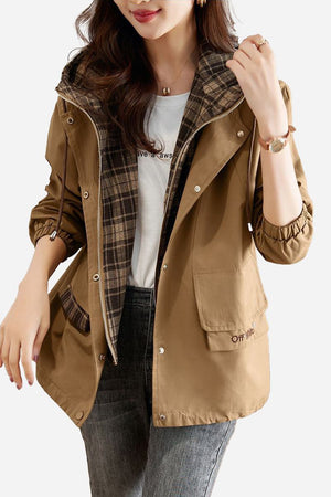 Women's City Explorer Plaid Windbreaker jacket with brown wind-resistant shell and plaid cotton lining, featuring elasticated cuffs, adjustable hood, and front flap pockets.