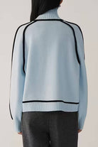 Back view of light blue Zero Itch turtleneck sweater with black contrast trim and relaxed fit.