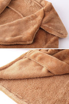 Close-up of soft brown faux fur fabric and draped collar of open front oversized fur jacket