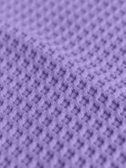 Close-up of soft purple cotton waffle knit fabric texture