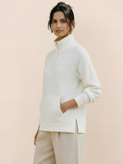 Half-zip waffle pullover with fold-over collar and front kangaroo pocket in neutral tones.