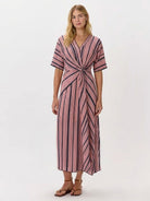 Woman wearing a knot-waist maxi dress with V-neckline and flowing skirt, featuring twist-knot detail and batwing sleeves
