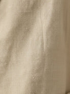 Hip-length cotton-linen blazer with notch lapels and two-button closure, featuring patch pockets and natural textured fabric.