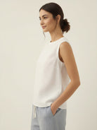 White cotton-linen sleeveless top with round neckline and back button closure