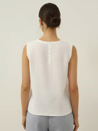 White cotton-linen sleeveless top with round neckline and button back closure