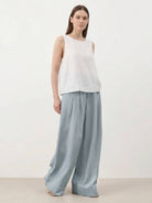 White Tencel-Linen pleated wide-leg pants with floor-skimming silhouette and hook-and-zipper waist closure