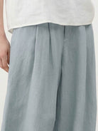 White Tencel-linen pleated wide-leg pants with hook-and-zipper waist closure and floor-skimming silhouette