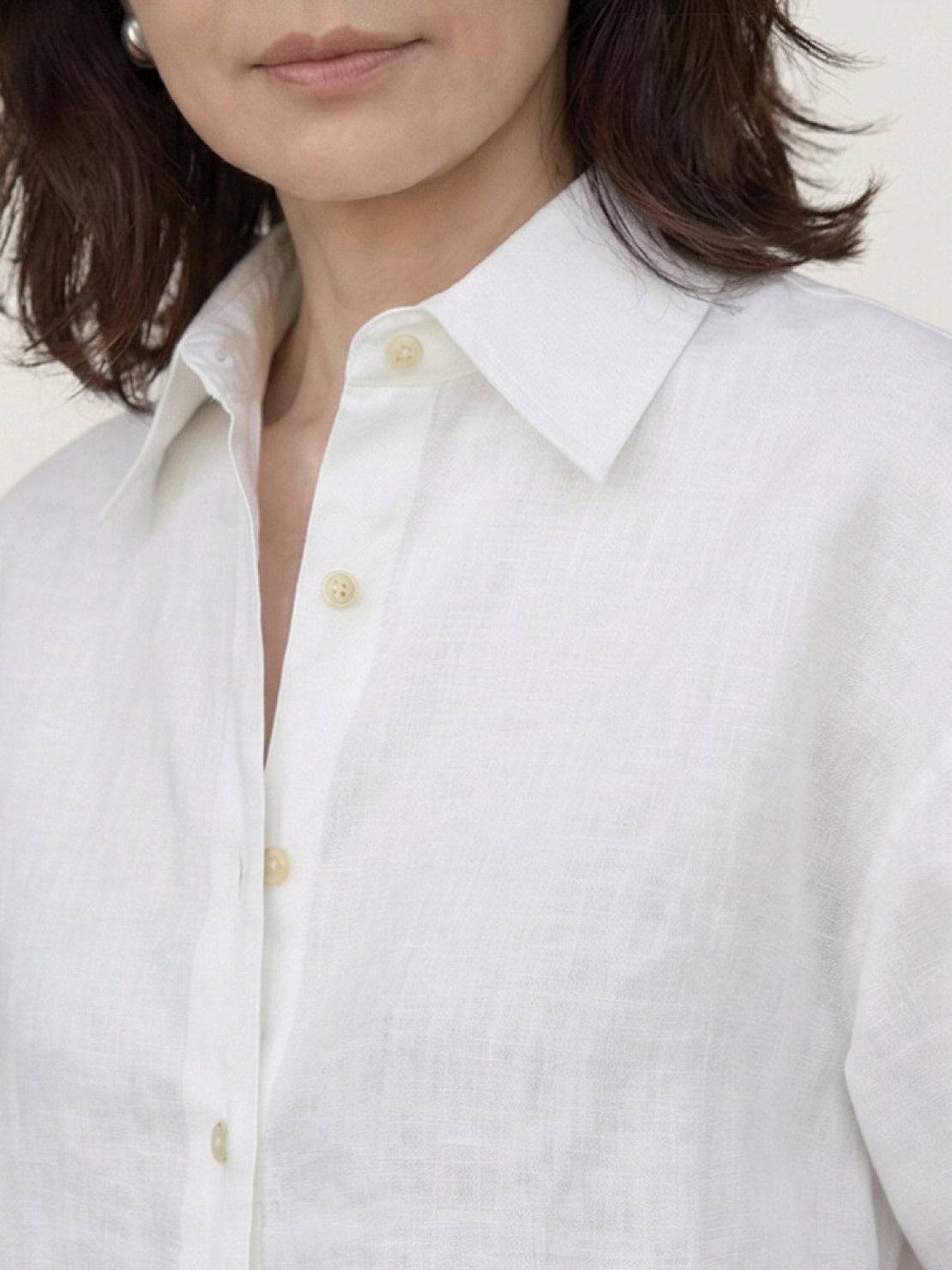 Loose 100% linen dropped-shoulder shirt with long rollable sleeves and side slits, hip-length relaxed fit.