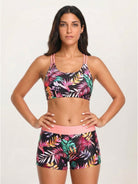 Woman wearing criss-cross back three-piece tankini set with sports bra and boy shorts