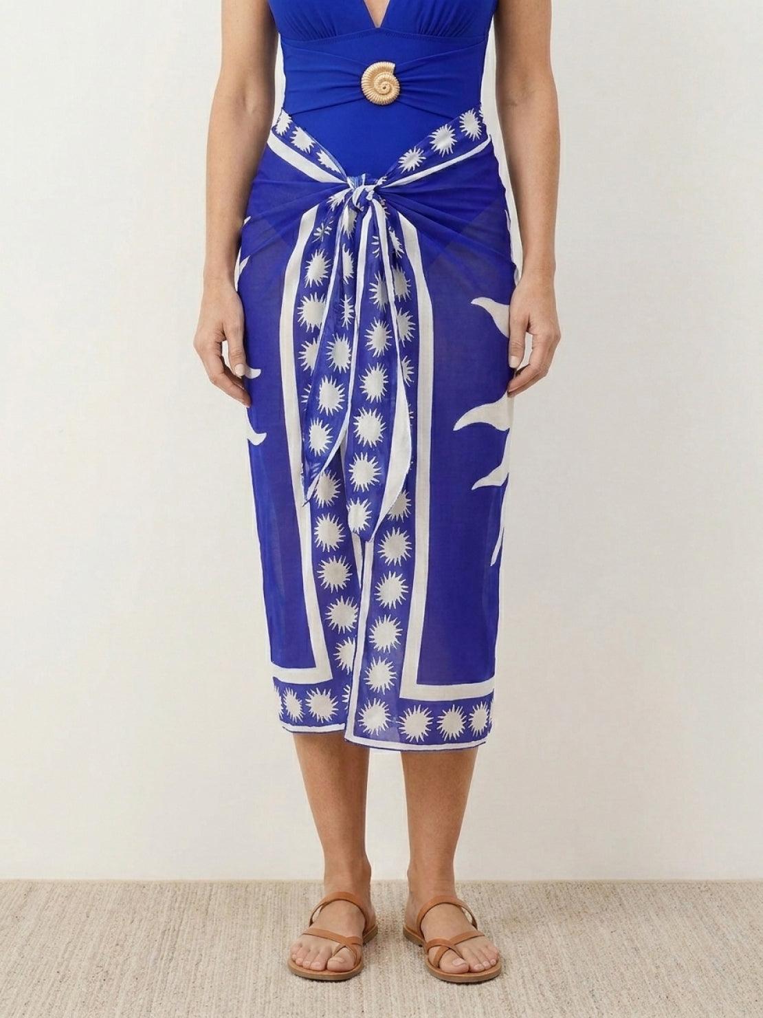 Deep-V swimsuit with ruched bust and waist, low open back, wide straps, and sheer celestial print sarong wrap