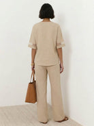 Mature woman wearing lightweight linen top with V-neck and button detail