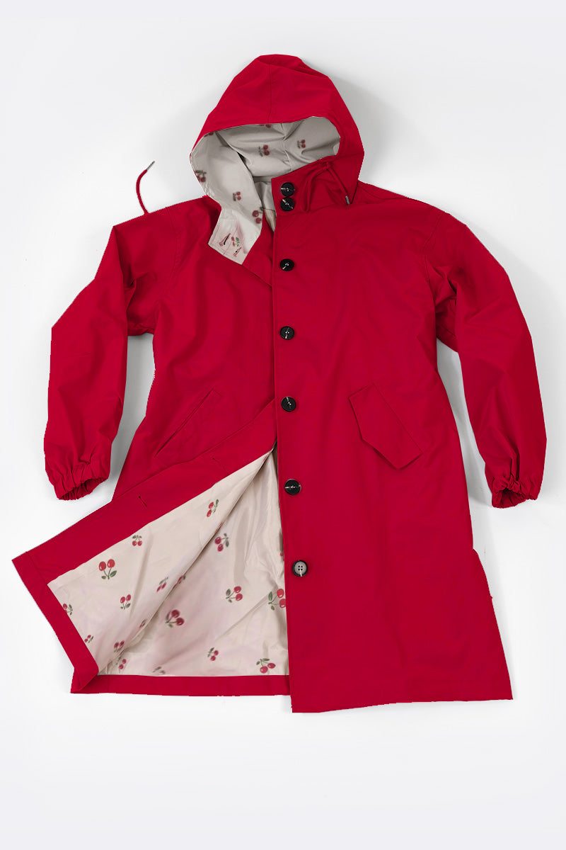 Red water resistant oversized windbreaker with hood and button closure, featuring light-colored inner lining with pattern.