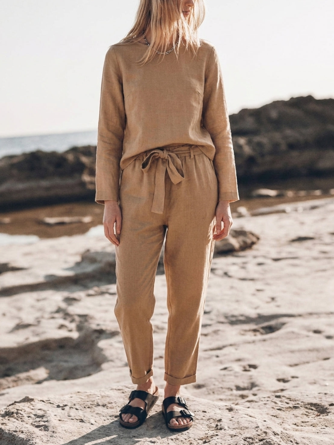 Woman wearing a cotton-linen monochrome relaxed longline top and wide-leg pants set in a minimalist style