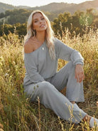 woman wearing gray round neck loose fit cozy two-piece set sitting outdoors in field