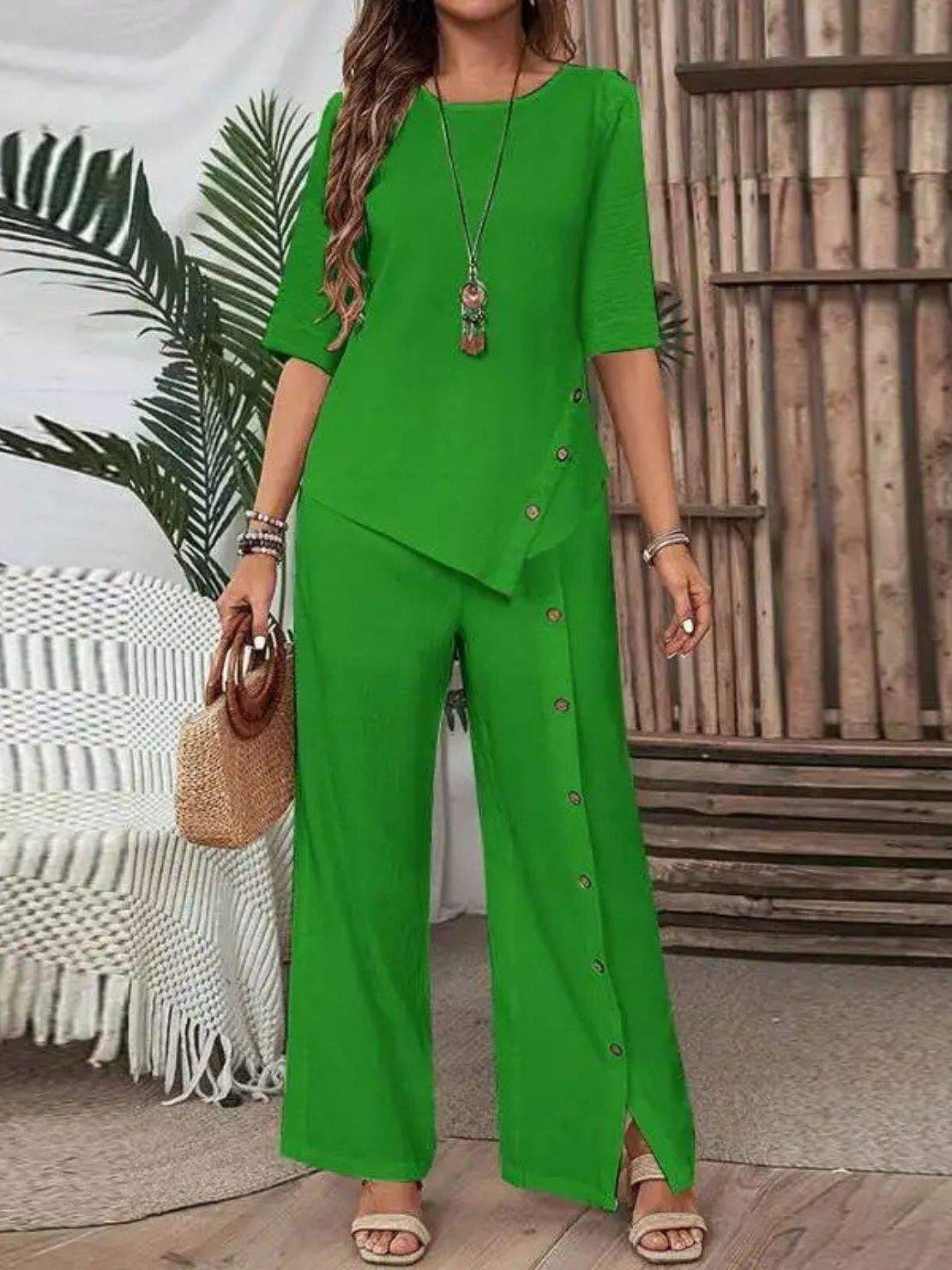 Woman wearing Asymmetry Flow Co-ord with button-front top and flowing long pants featuring asymmetrical hem.