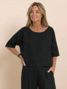 Woman wearing black short-sleeved pullover and wide trouser matching set with loose, comfortable fit