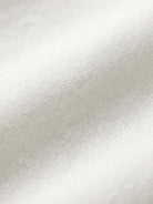 Close-up of soft white cotton fabric texture for short-sleeved pullover and wide trouser matching set