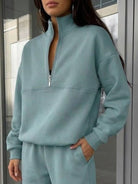 Woman wearing a stylish cotton-blended two-piece tracksuit with high collar and zipper, showcasing casual athleisure comfort and polished design.