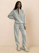 Woman wearing a stylish cotton-blended two-piece tracksuit with high collar and zipper, showcasing comfy athleisure fashion.