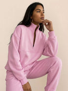 woman wearing cotton-blended two-piece tracksuit with high collar and zipper, showcasing athleisure style