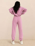 Woman wearing a cotton-blended two-piece tracksuit with high collar and zipper on city street